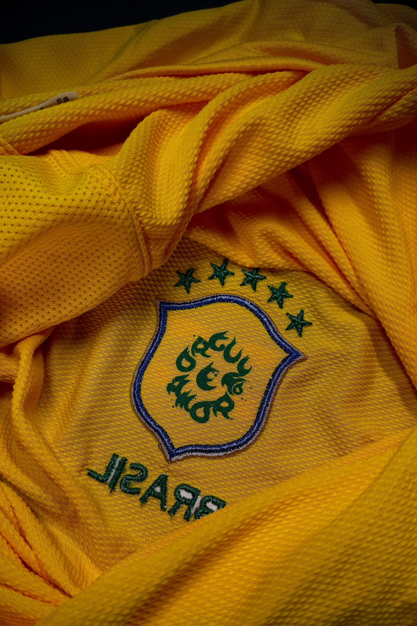 Close-up of a yellow sports jersey with a logo and text