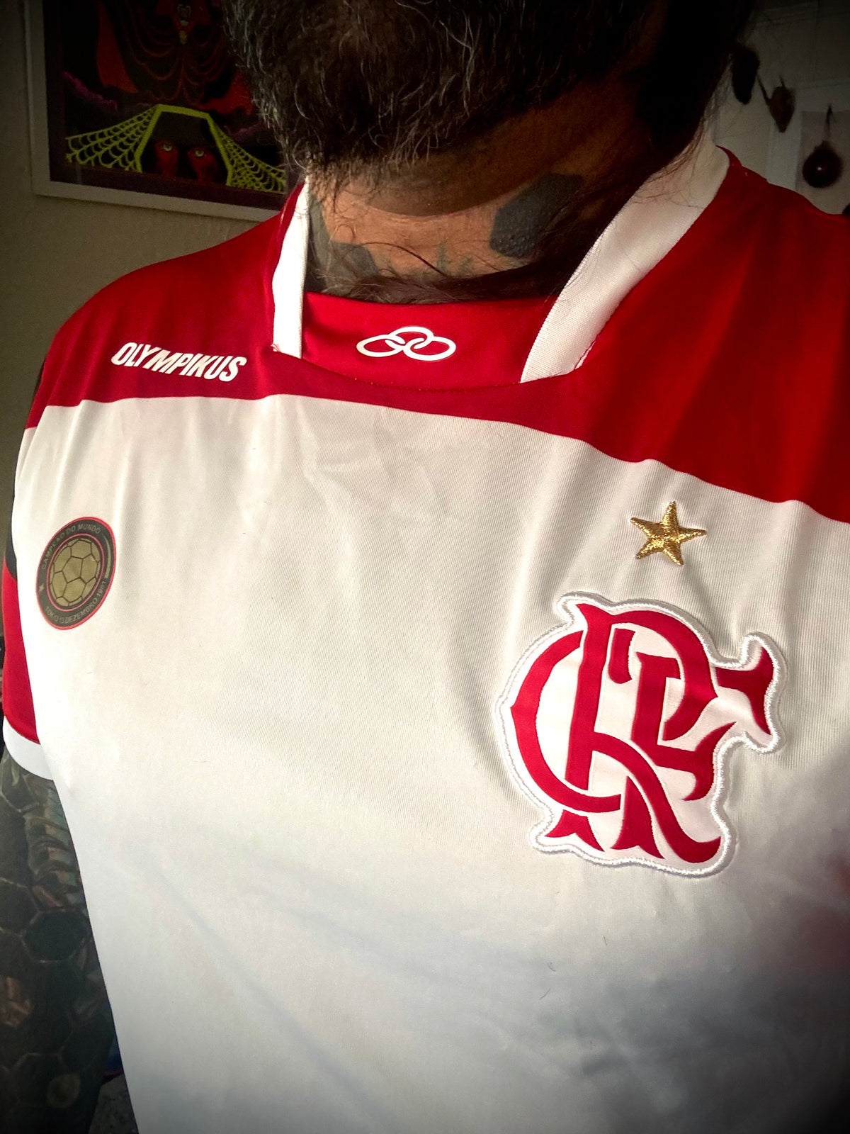 A white and red Flamengo soccer jersey with the Olympikus brand logo, featuring a patch commemorating 30 years of the World Cup Club Champion.