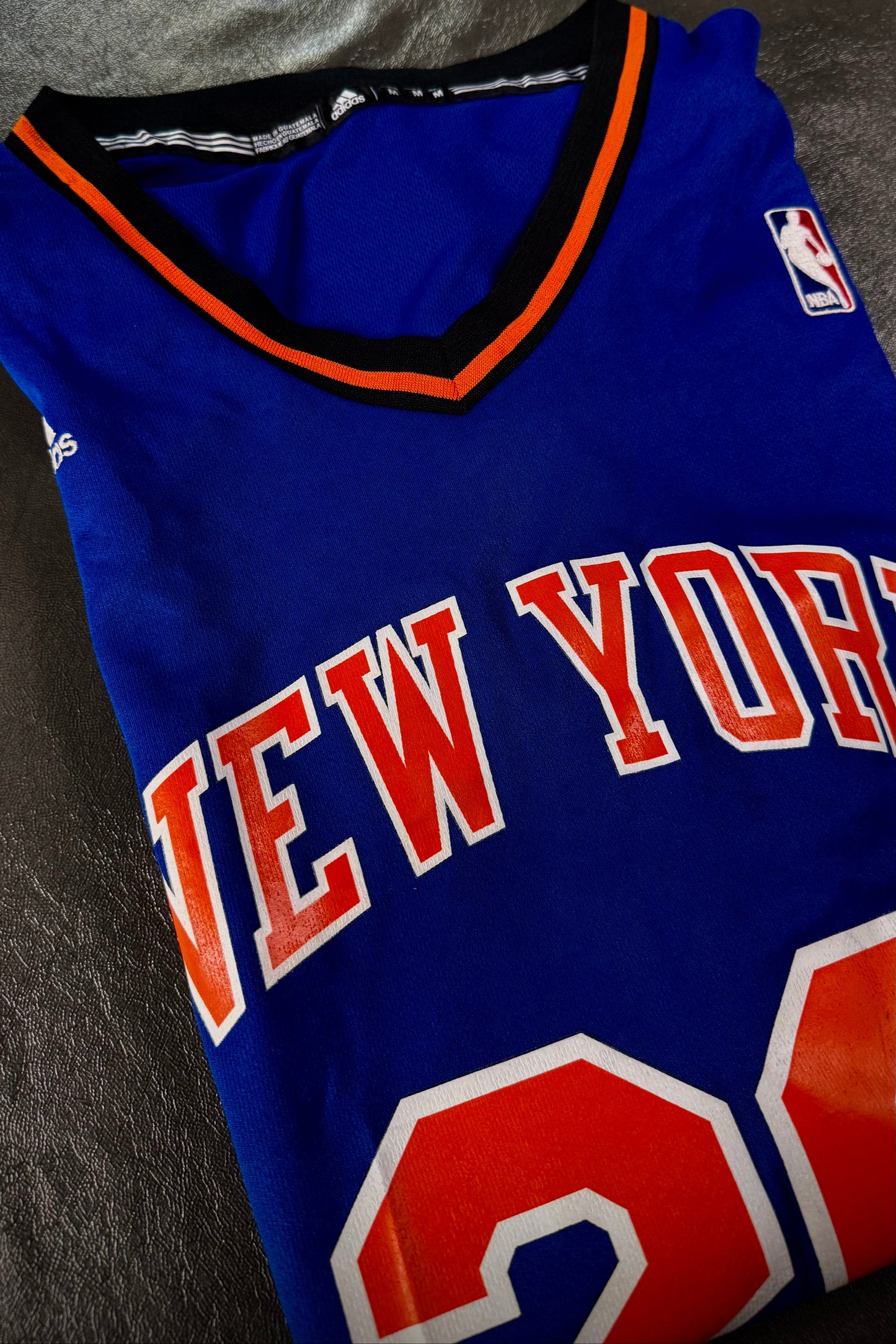 Blue sports jersey with 'New York' and number '23' on a dark surface