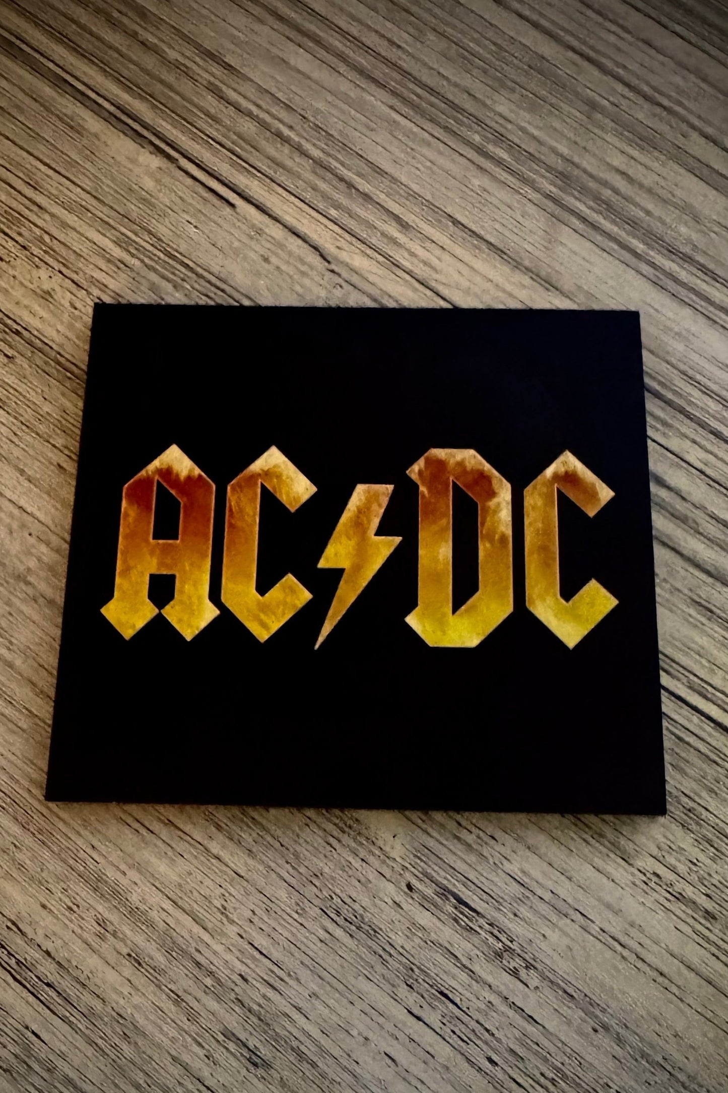 Digipak CD case of AC/DC Black Ice album with band's logo in yellow and orange on a black background.