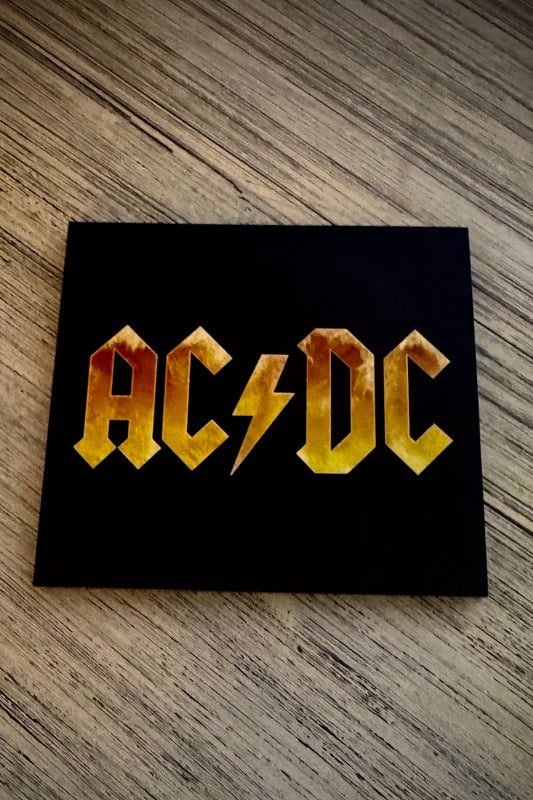 Digipak CD case of AC/DC Black Ice album with band's logo in yellow and orange on a black background.