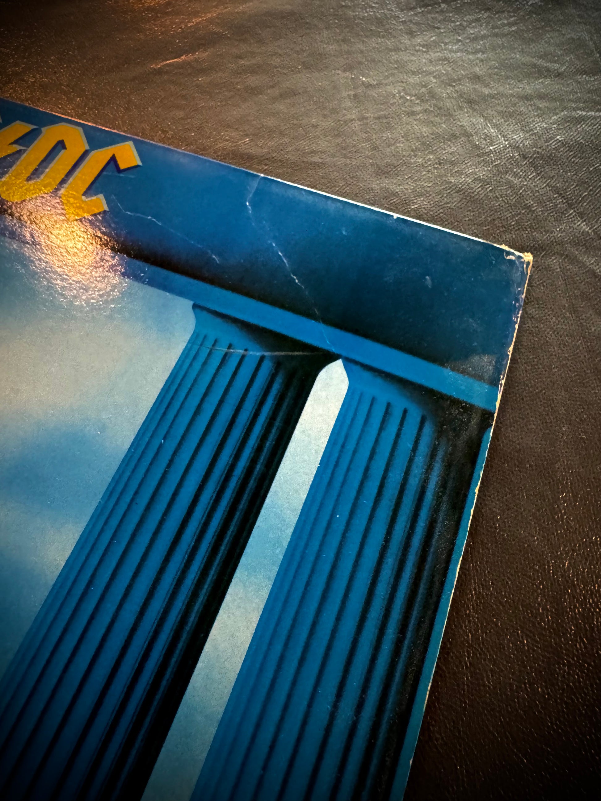 Close-up of a blue object with 'DC' branding on a dark surface