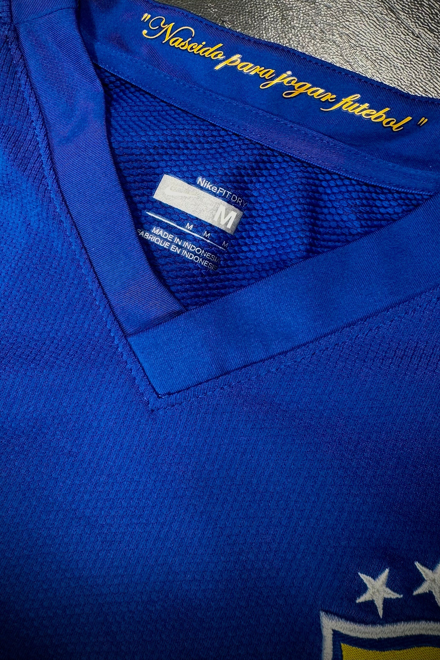 Close-up of a blue sports jersey with text and branding on a dark background