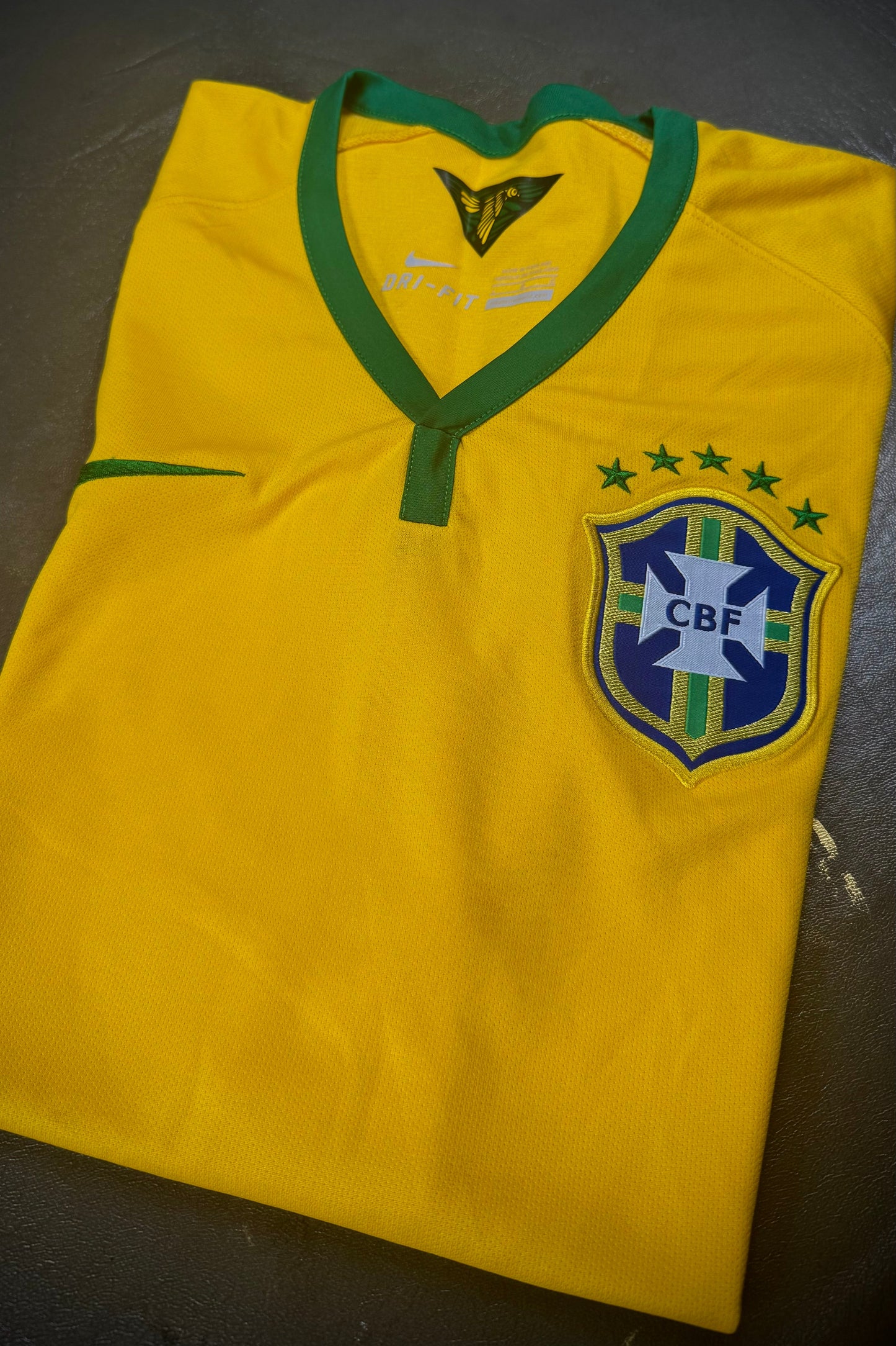 Yellow sports jersey with a logo on a dark surface