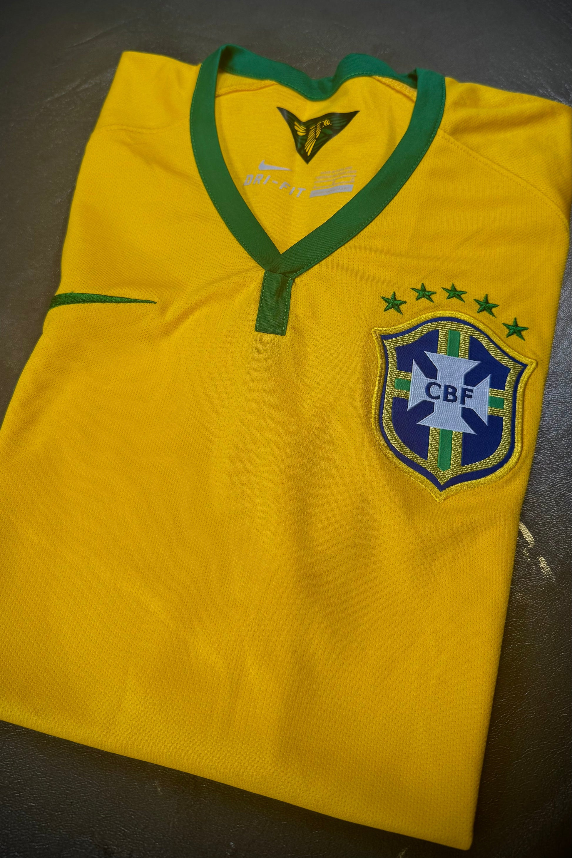 Yellow sports jersey with a logo on a dark surface