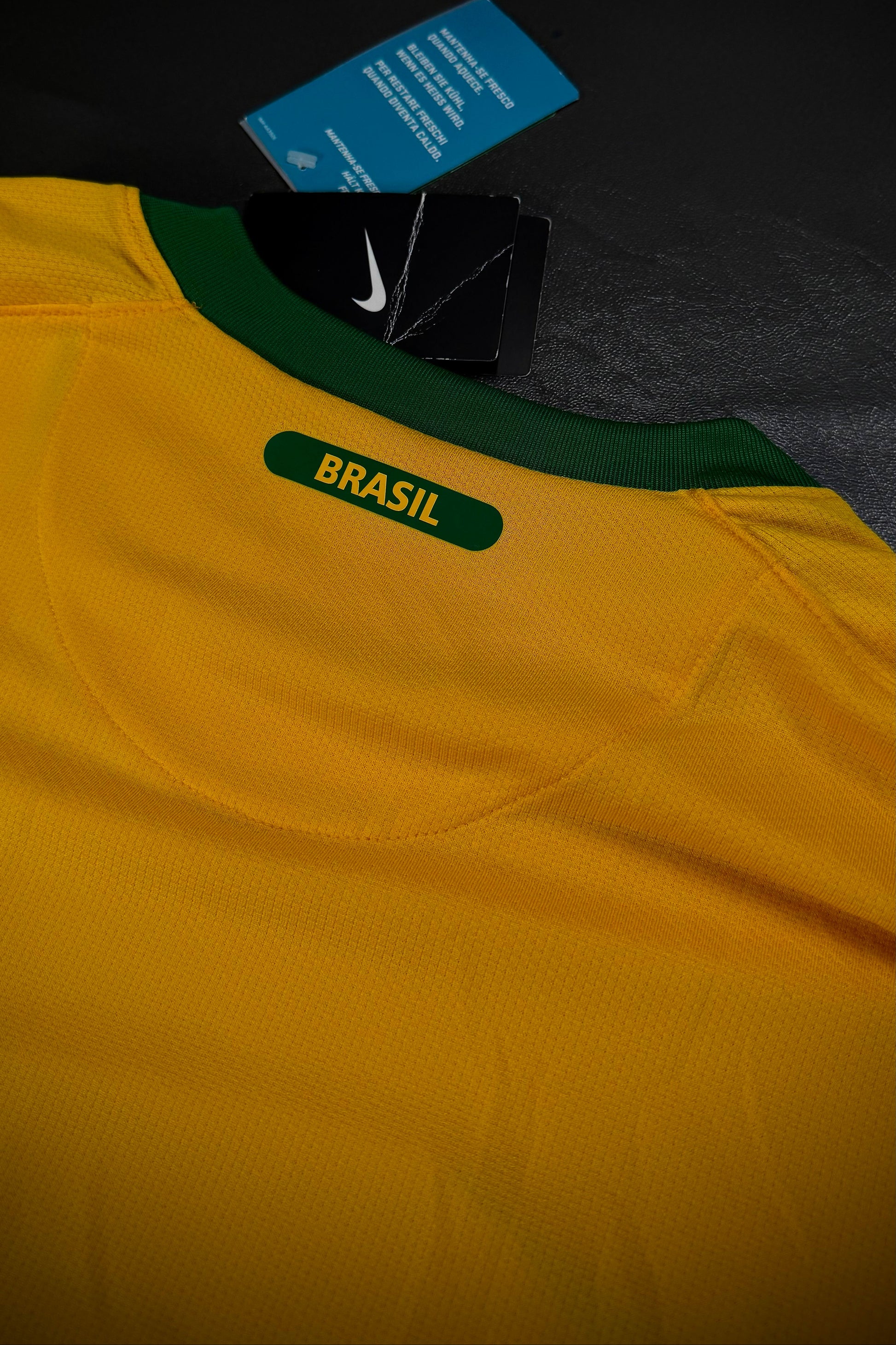Yellow sports jersey with 'Brasil' label and Nike logo on a dark background