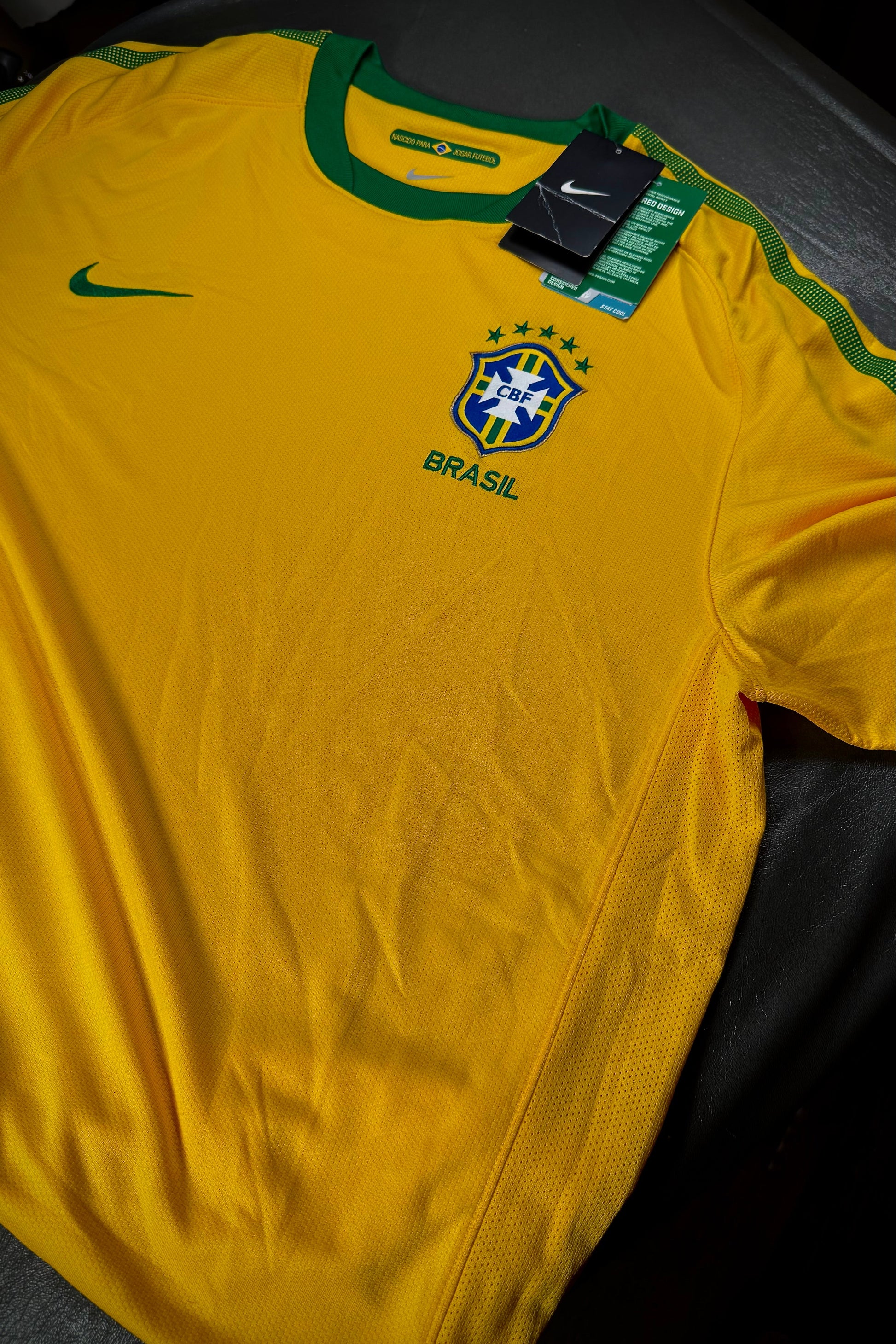 Yellow sports jersey with 'Brasil' text and Nike logo on a dark surface