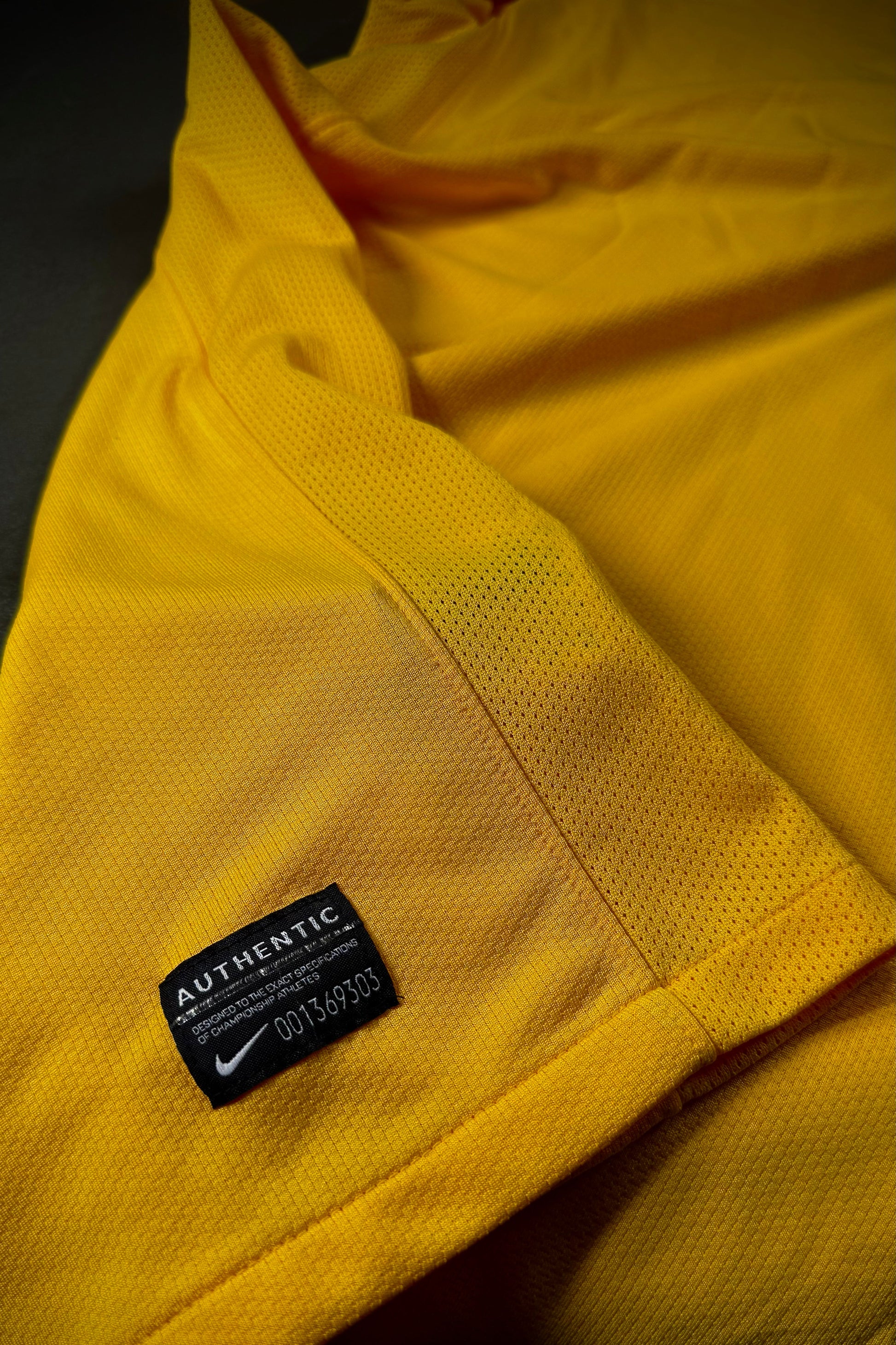 Close-up of a yellow jacket with a Nike authenticity label.