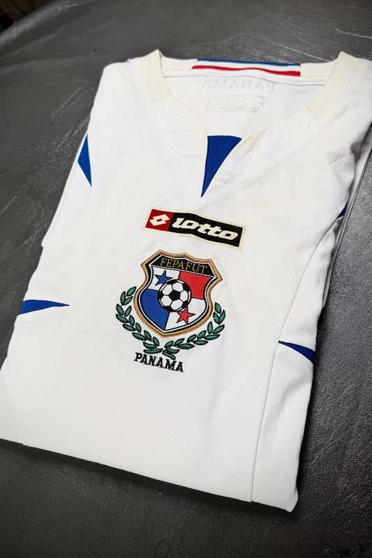 Folded white sports jersey with logos on a gray surface