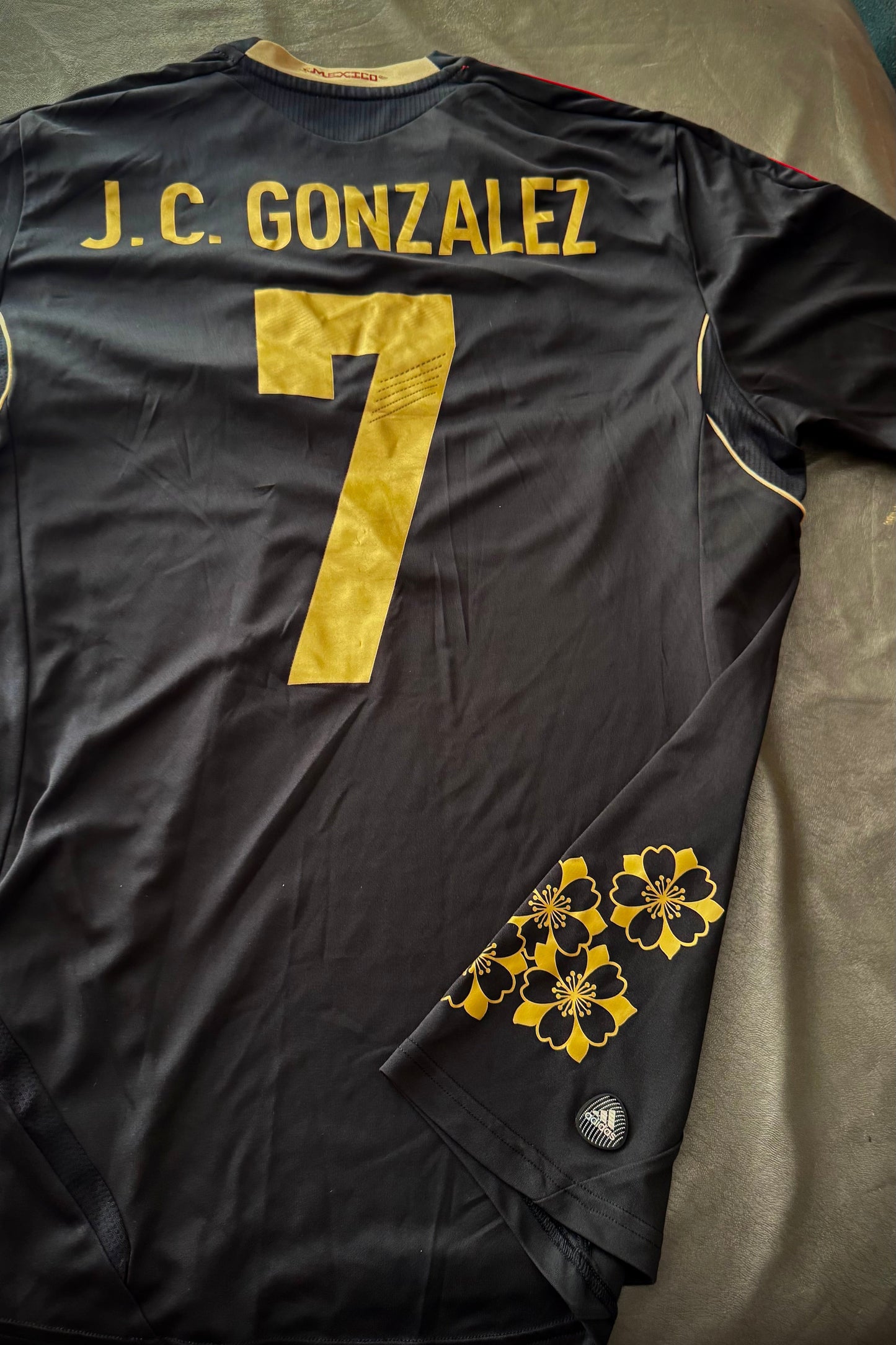 Black sports jersey with 'J.C. Gonzalez' and number '7' on a bed