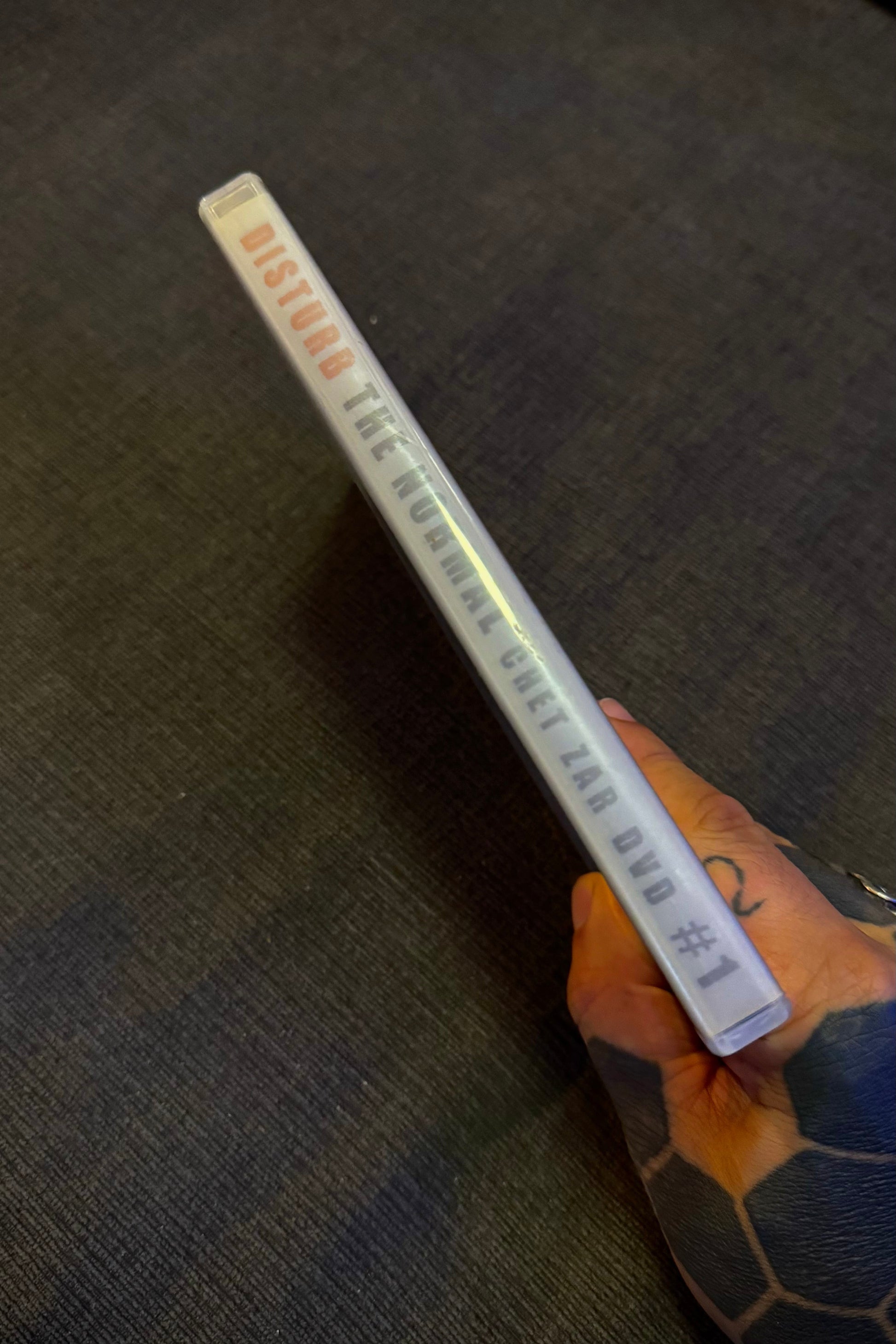 Long rectangular object with text on a dark textured surface