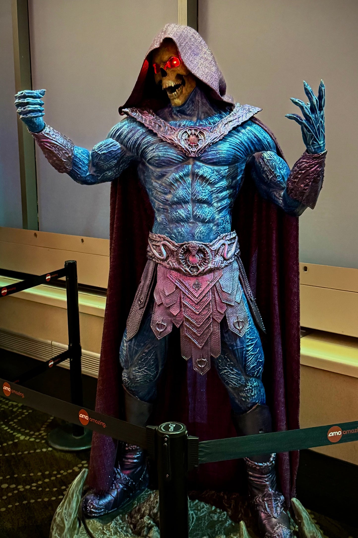 Costume figure with blue and purple design, standing indoors.
