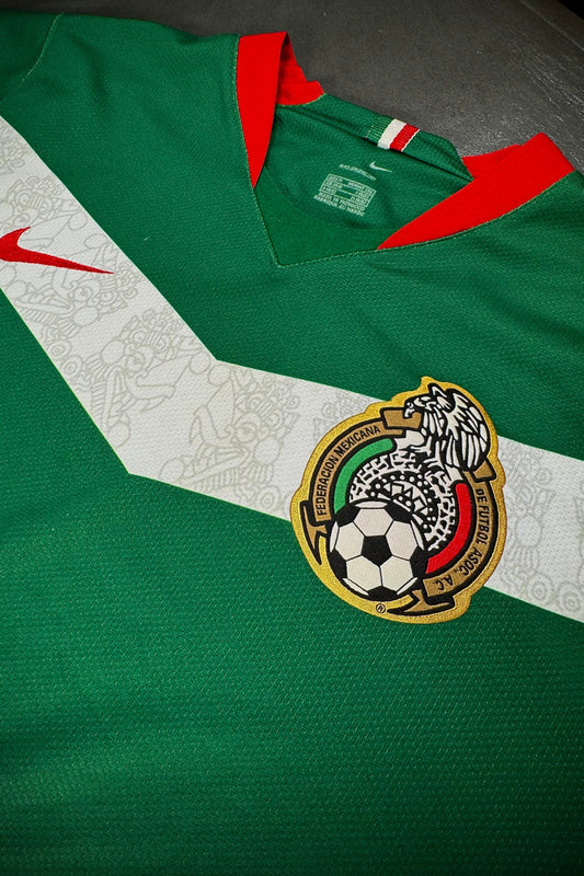 Green sports jersey with a logo featuring a soccer ball on a white background