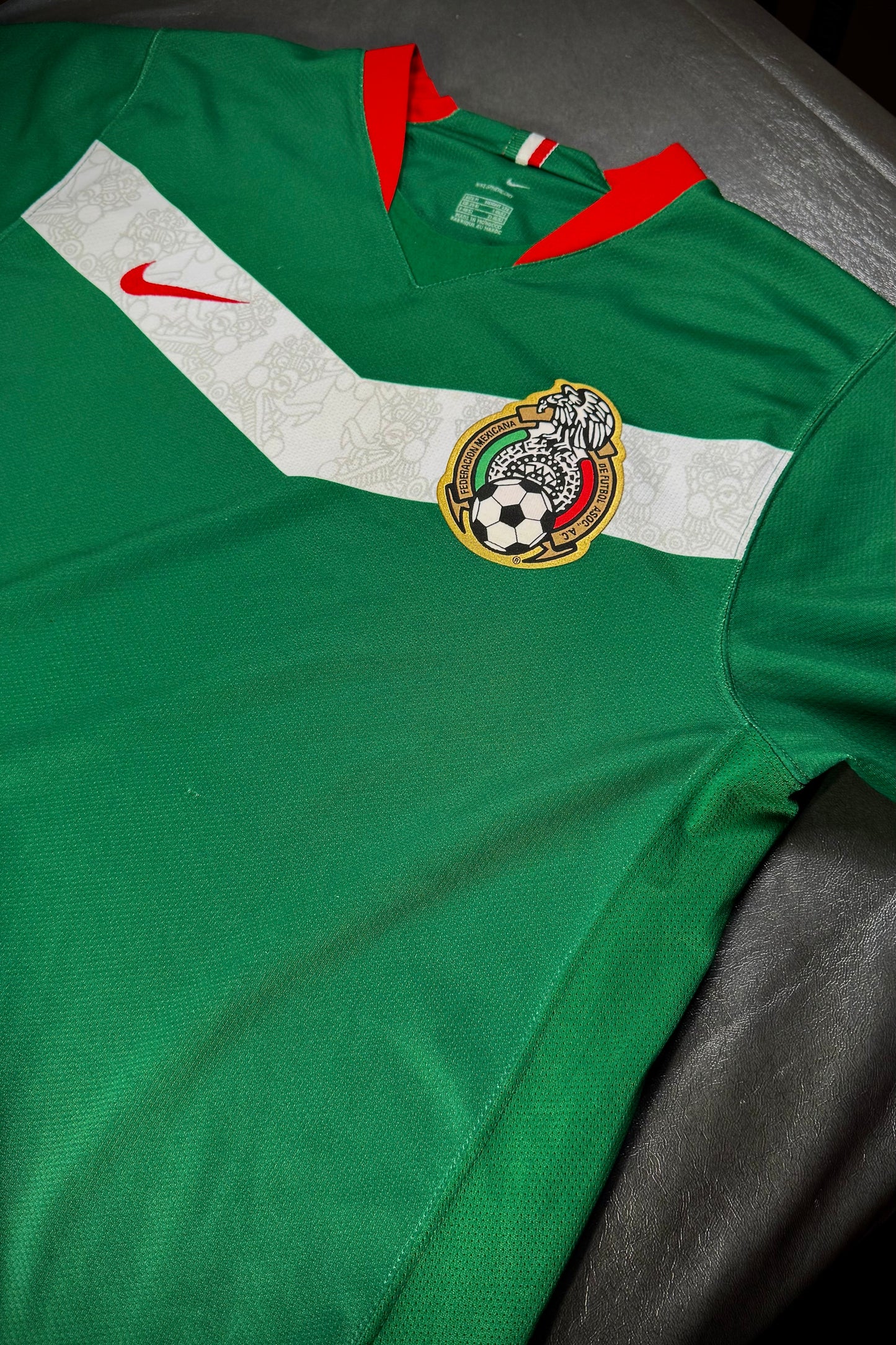 Green sports jersey with Nike logo and emblem on a dark surface