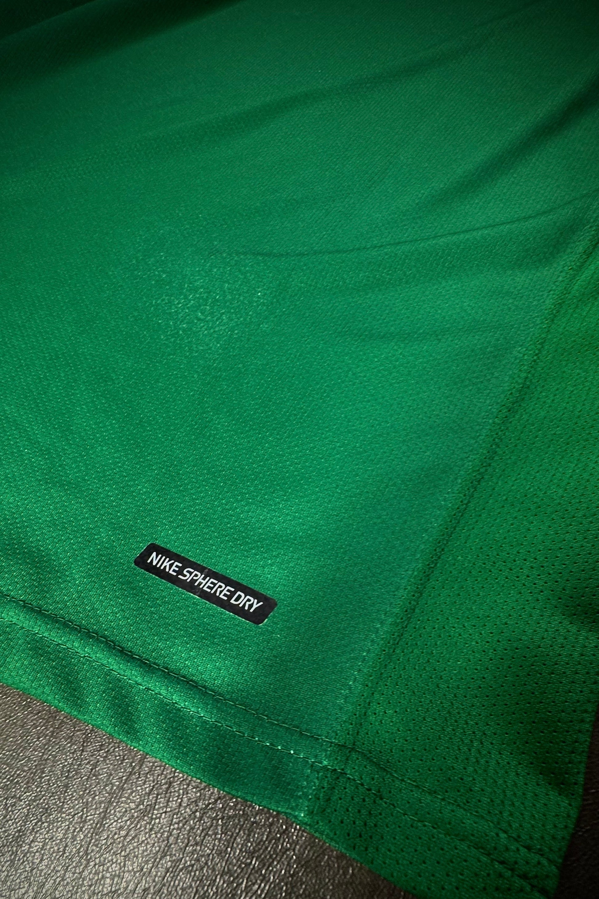 Green fabric with a Nike Sphere Dry label on a dark surface