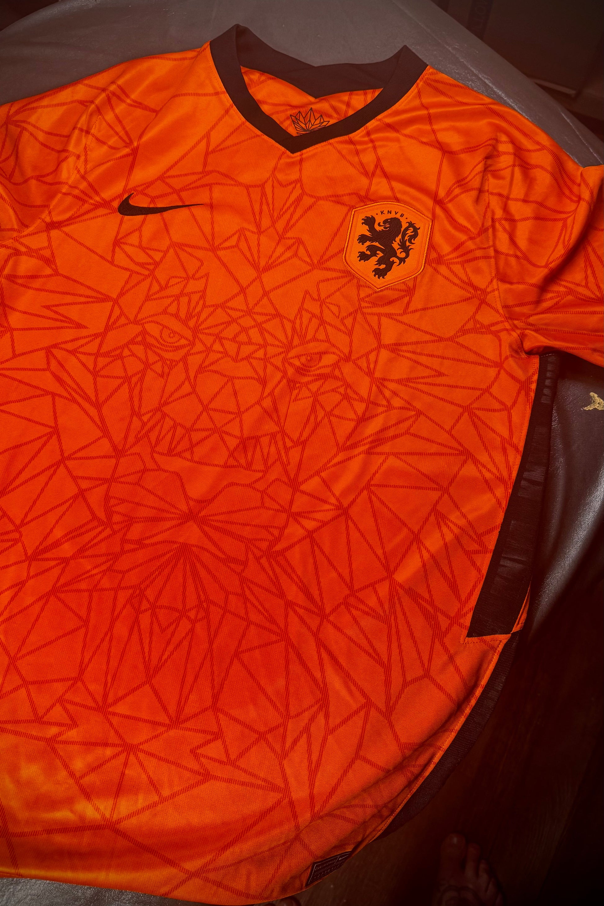 Orange sports jersey with a logo on a table