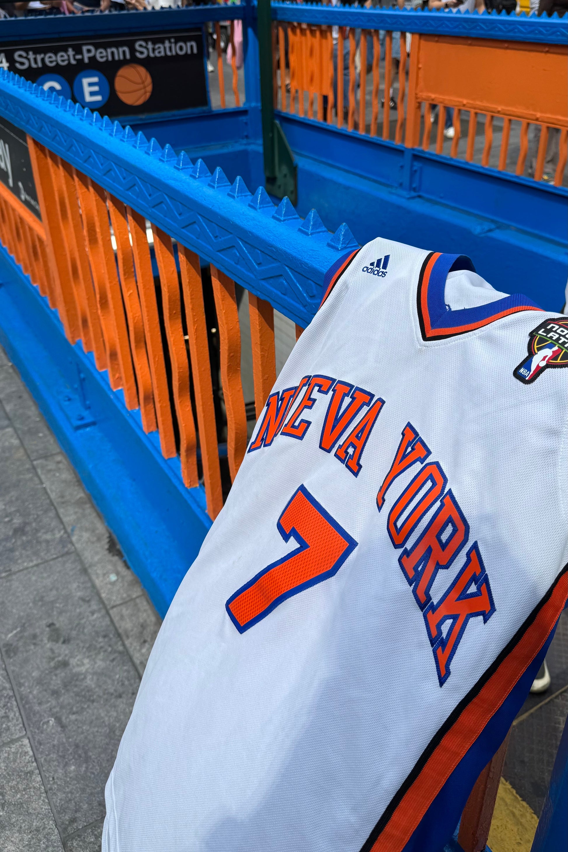 New York sports jersey with number 7 hanging on a blue and orange railing.