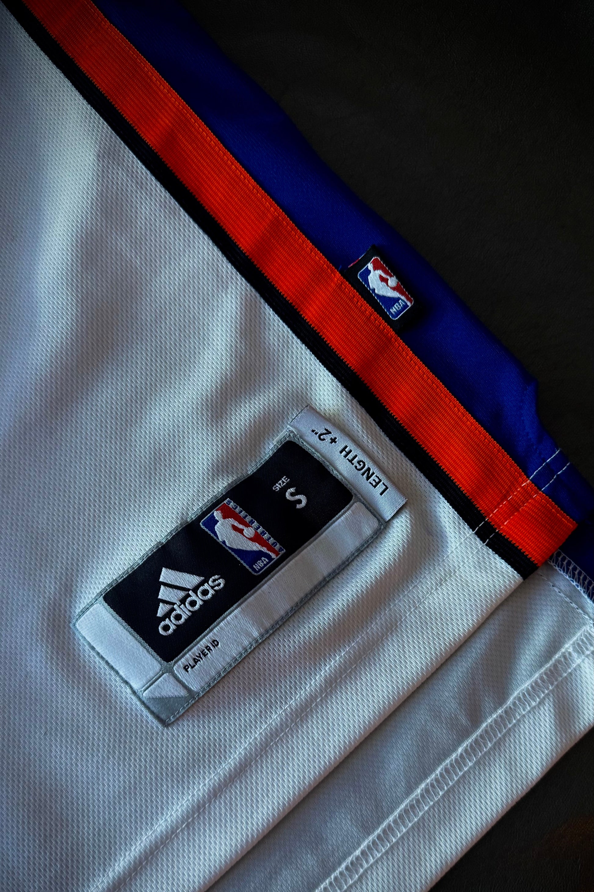 Close-up of a sports jersey with Adidas and NBA logos on a dark background