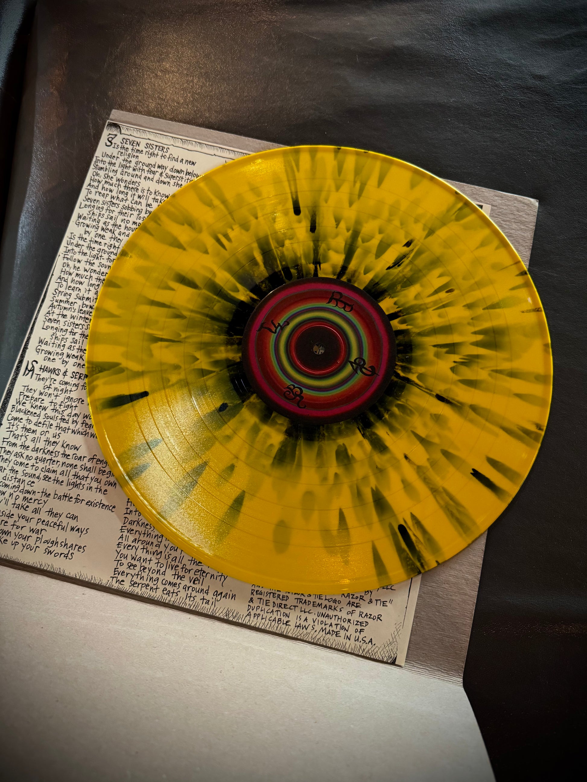 Yellow record with a colorful center on top of a book
