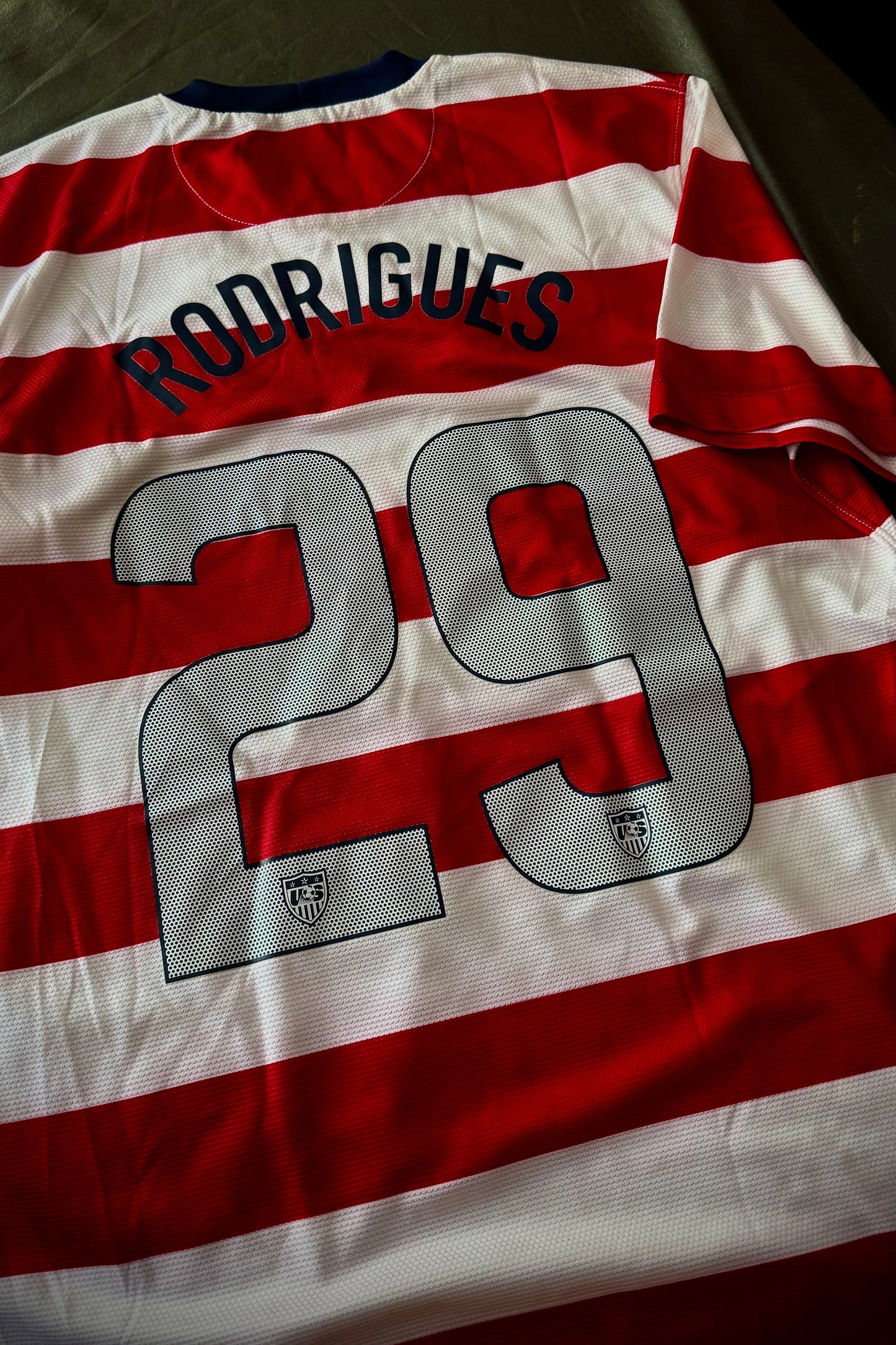 Red and white striped sports jersey with 'Rodrigues' and number '29' on a chair.