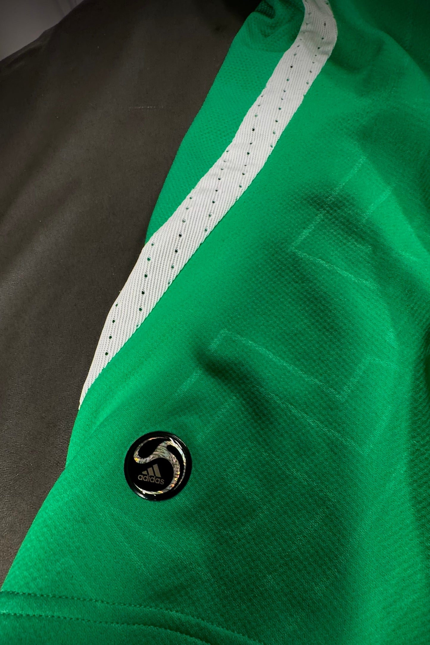 Close-up of a green jacket with a brand logo on a dark background