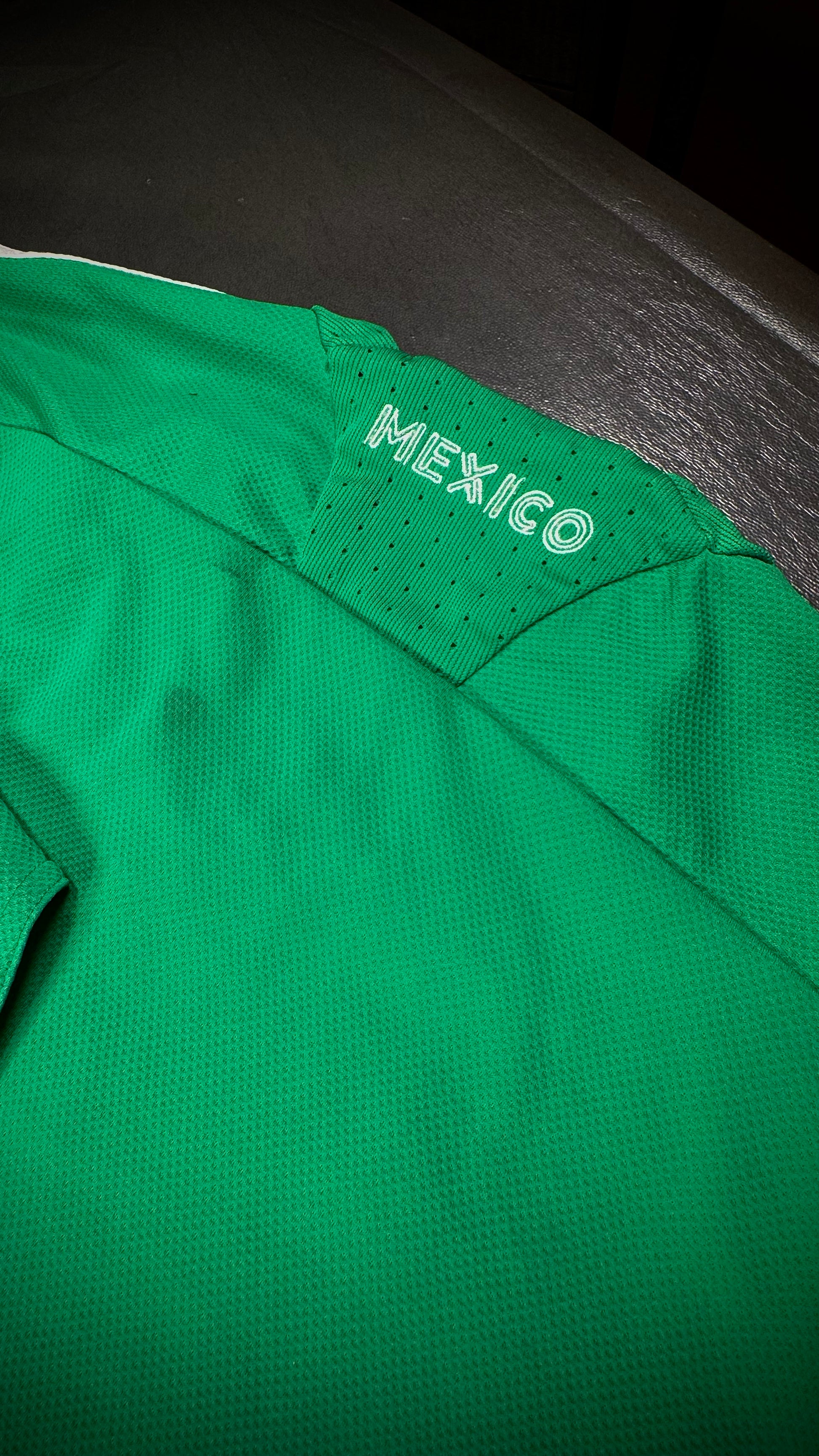 Green sports jersey with 'Mexico' text on a dark background
